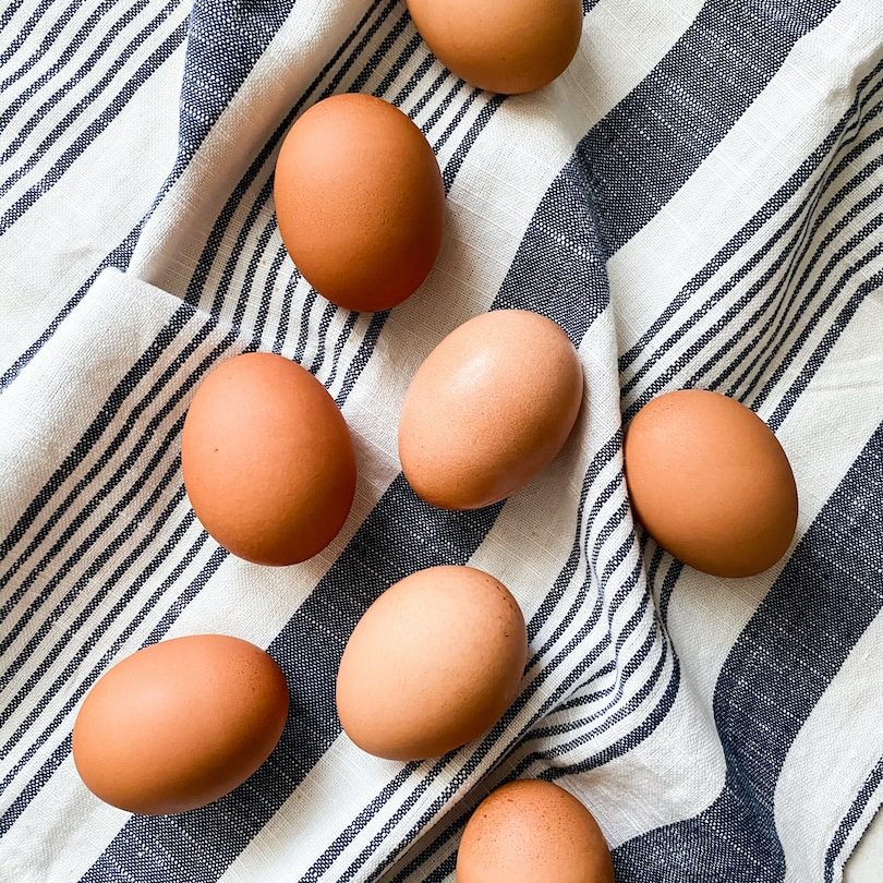 brown egg on white and blue stripe textile